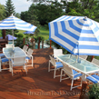 Umbrellas, tables, and chairs arranged on a Brazilian Teak deck